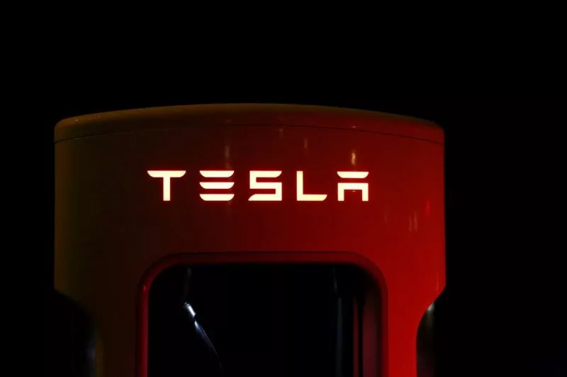 A Red Tesla Charger at night. 